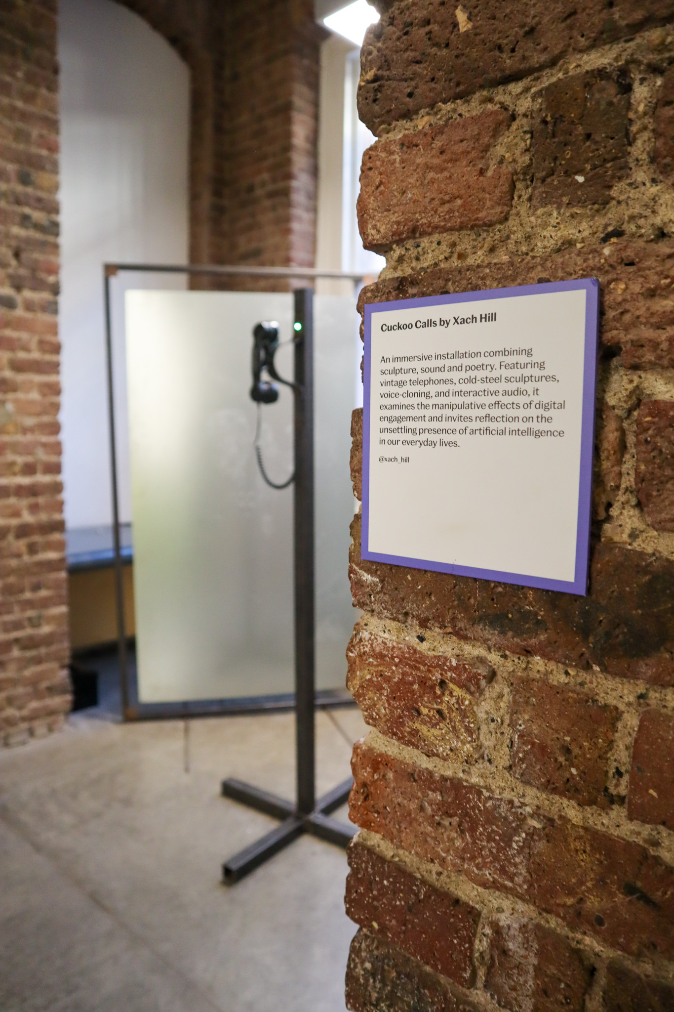 Phone on a metal pole with a red light ontop of it